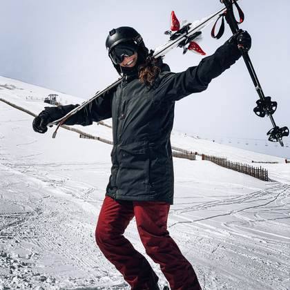 A skier throws their arms to the peaks