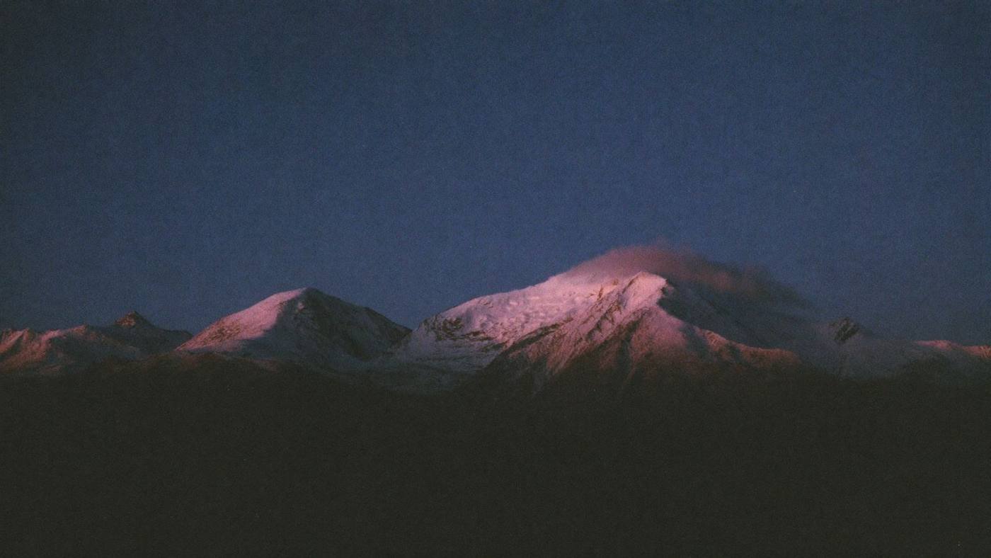 Snow peak glowing with alpenglow at dusk